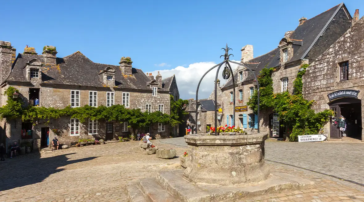 An attractive village square with period stone properties and a well.