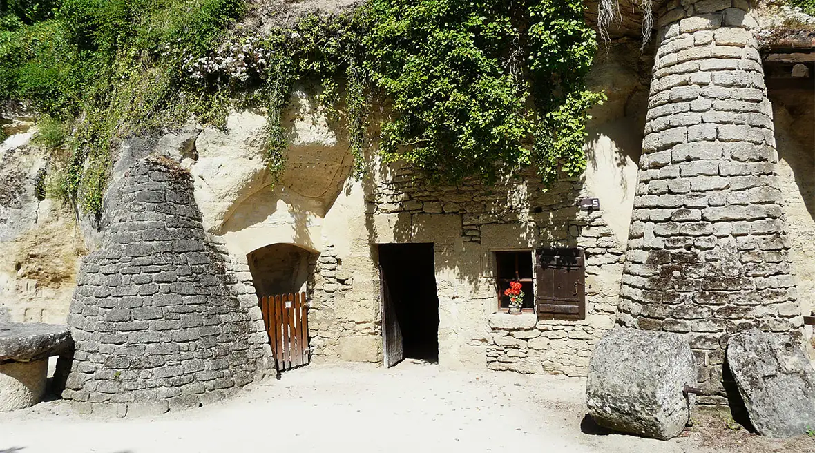 A cave building with chimney-type structures either side of the house