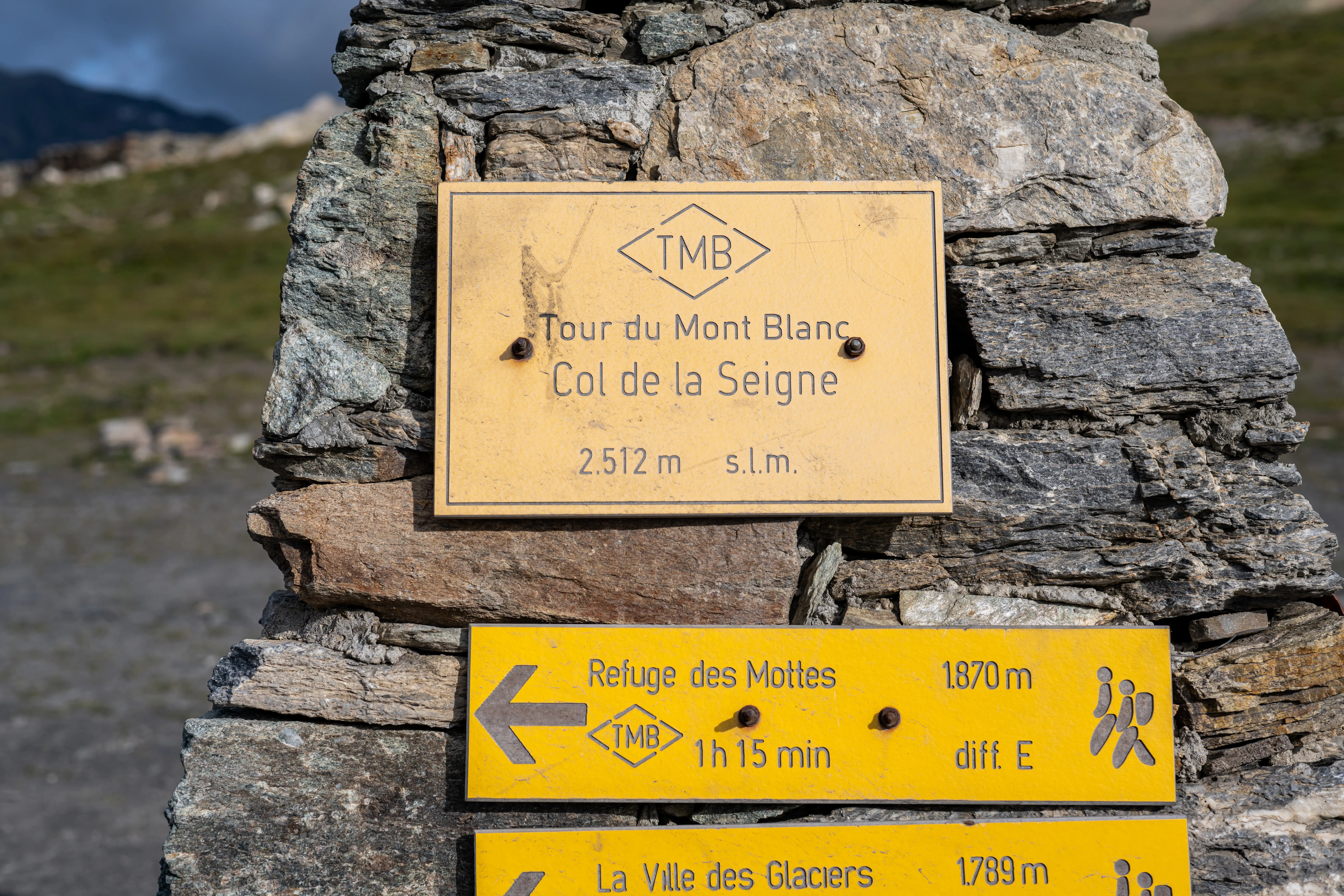 Signposts on a rock on the Tour du Mont Blanc