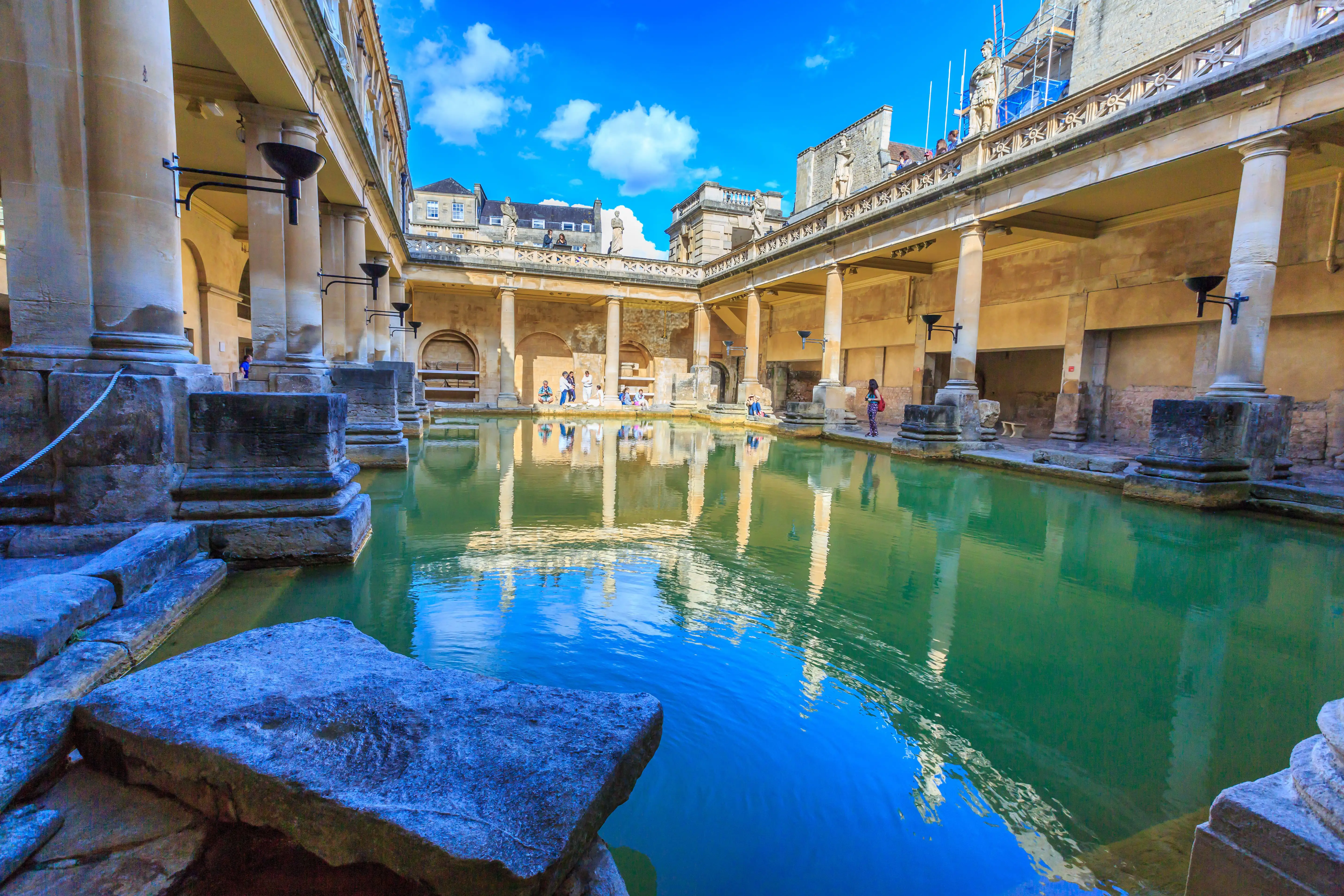 Beeld van de Romeinse baden in Bath omringd door klassieke zuilen en stenen muren.