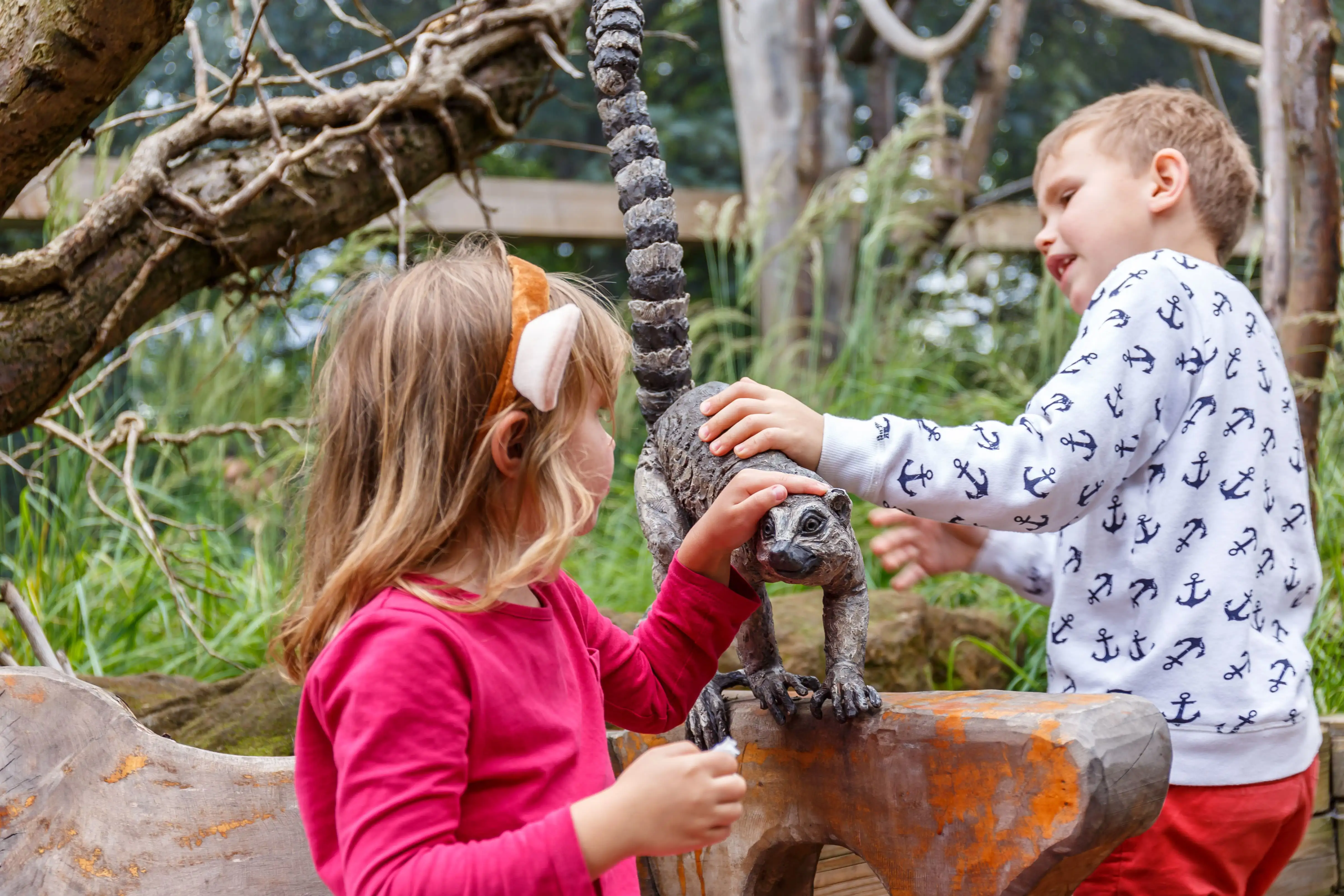 Des enfants caressant une sculpture de lémurien au Zoo de Londres.
