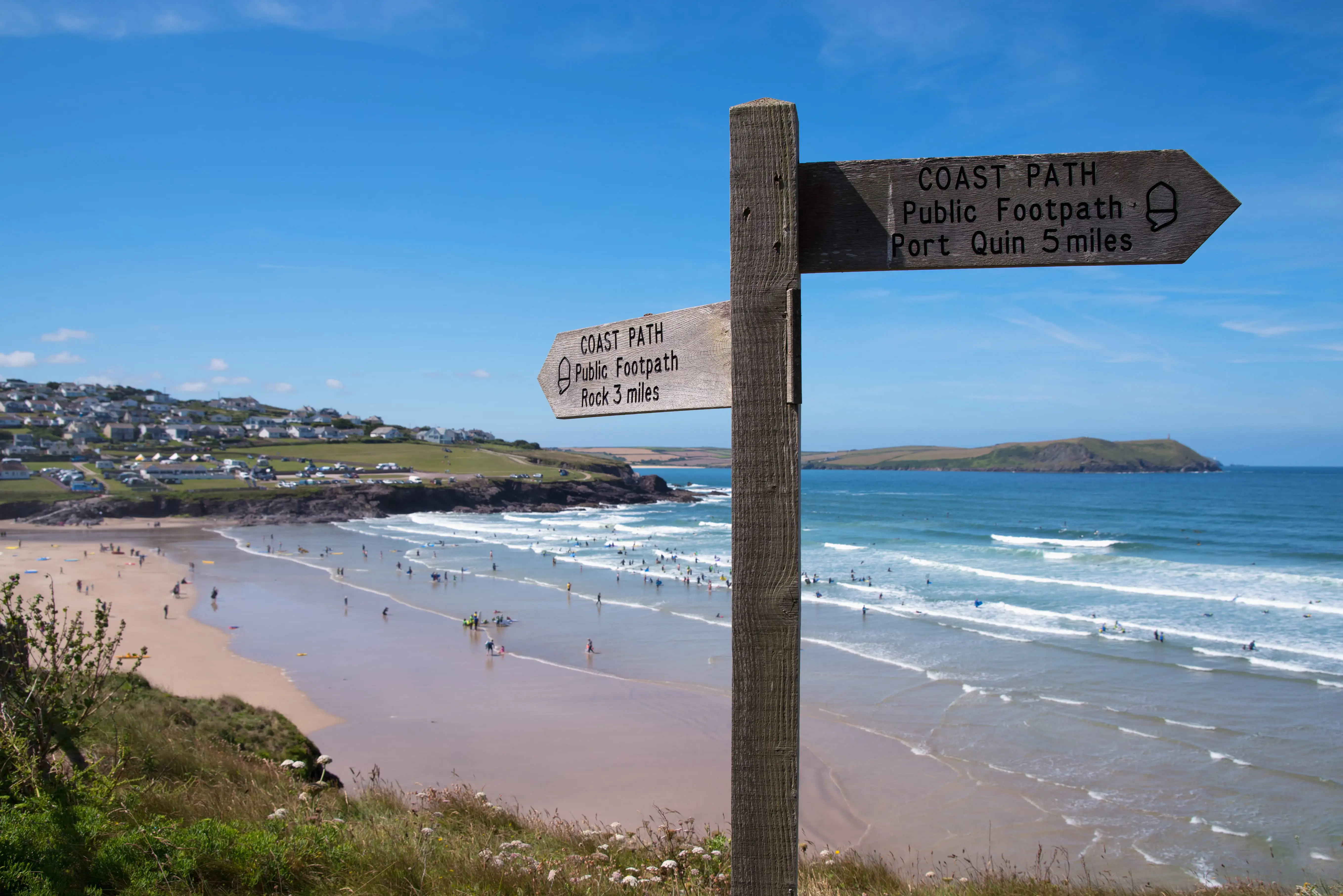 Wegweiser auf dem South West Coast Path oberhalb des Strandes von Polzeath, Cornwall.