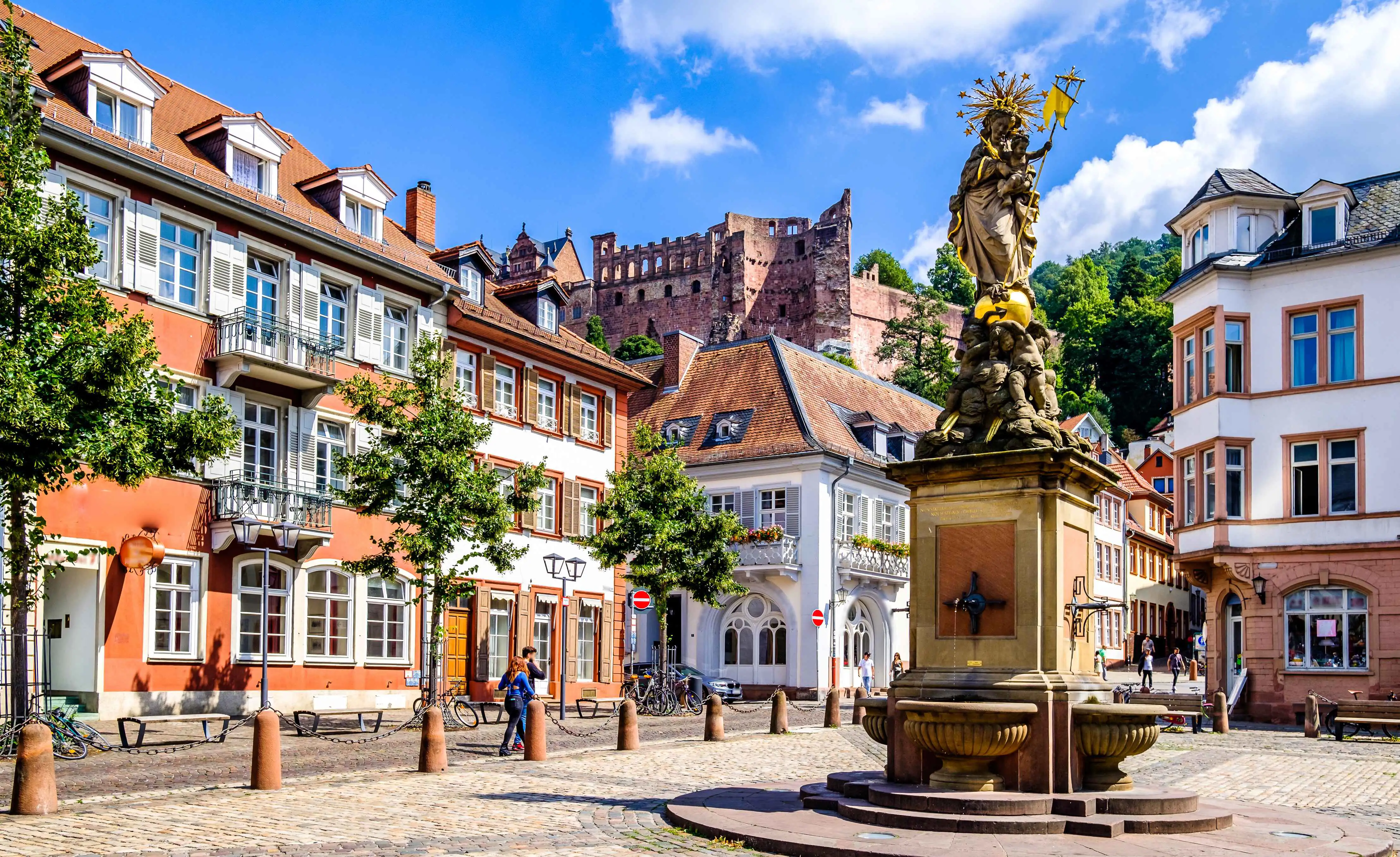 The Madonna fountain in the Kornmarkt, Heidelberg, with Heidelberg castle in the background