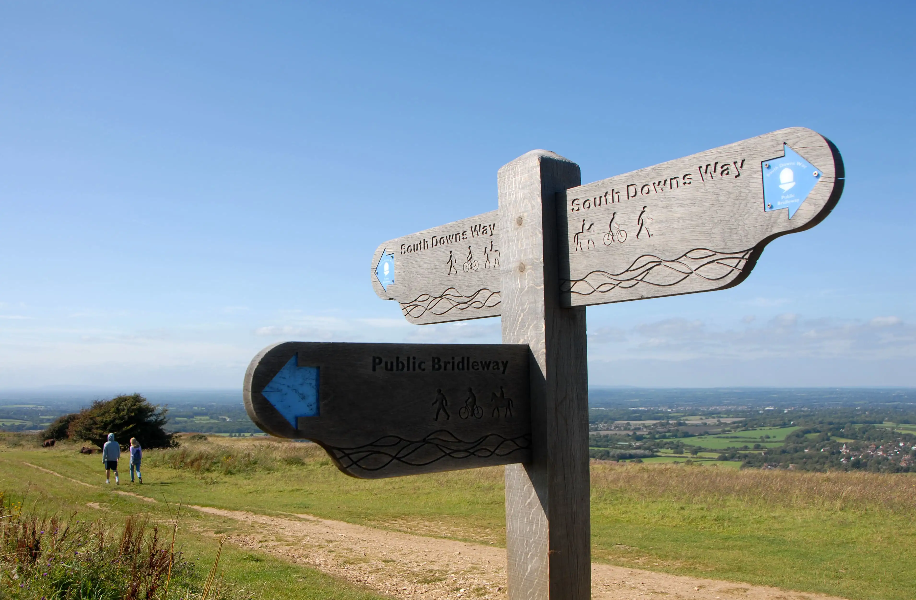 Des promeneurs sur le South Downs Way dans le Sussex avec un panneau au premier plan.