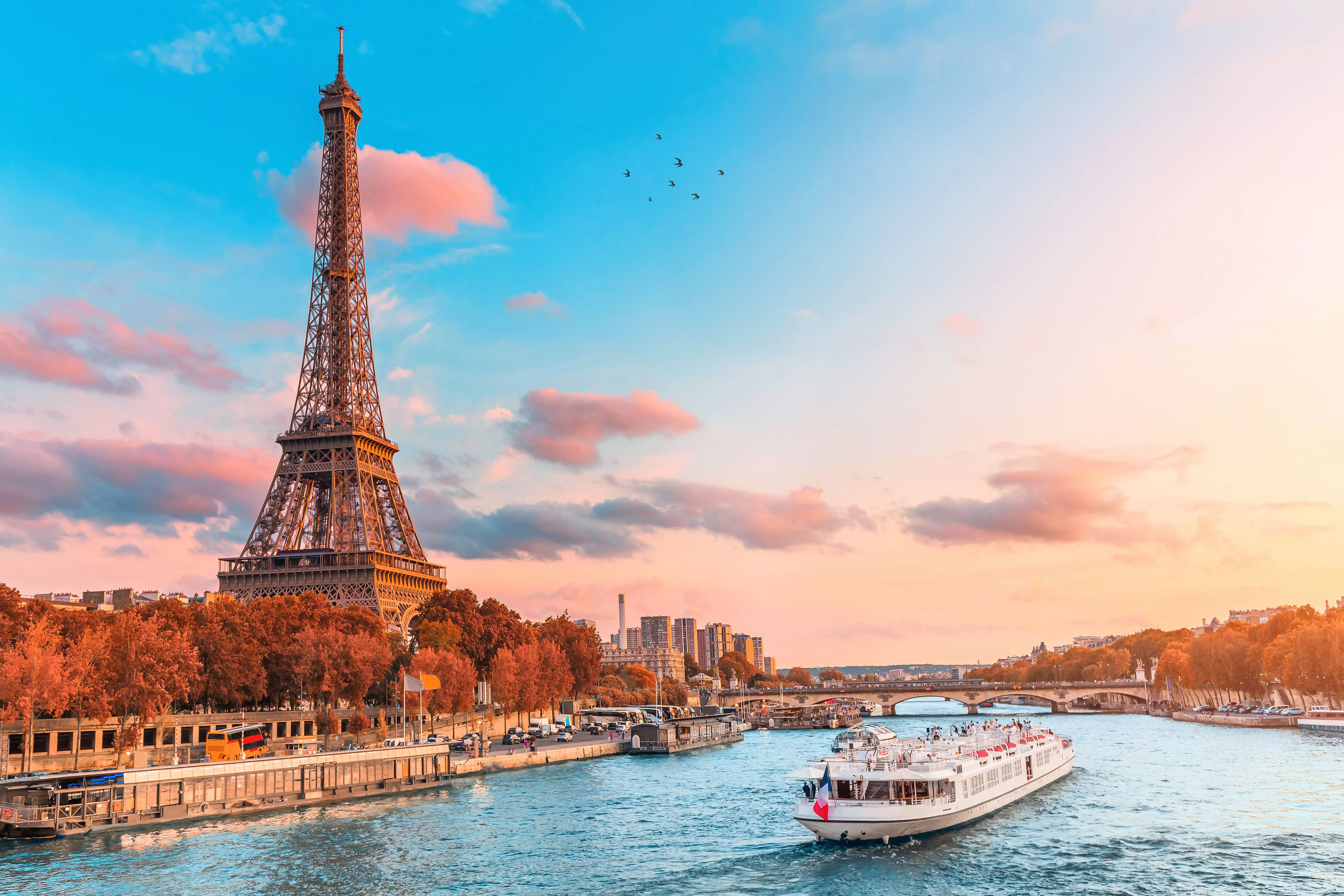 A Seine river cruise boat floating past the Eiffel Tower