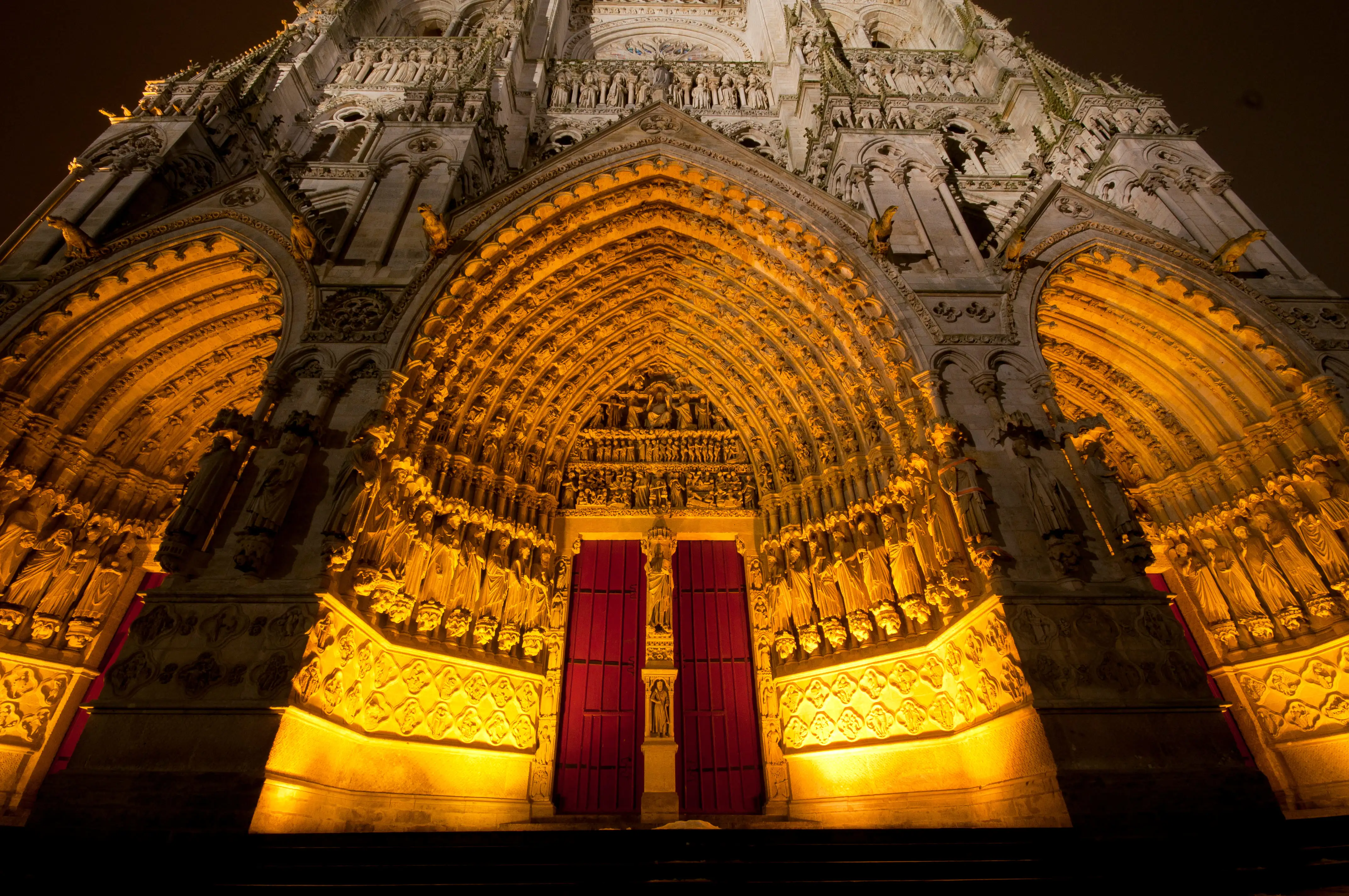The doors of Amiens cathedral lit up evocatively at night