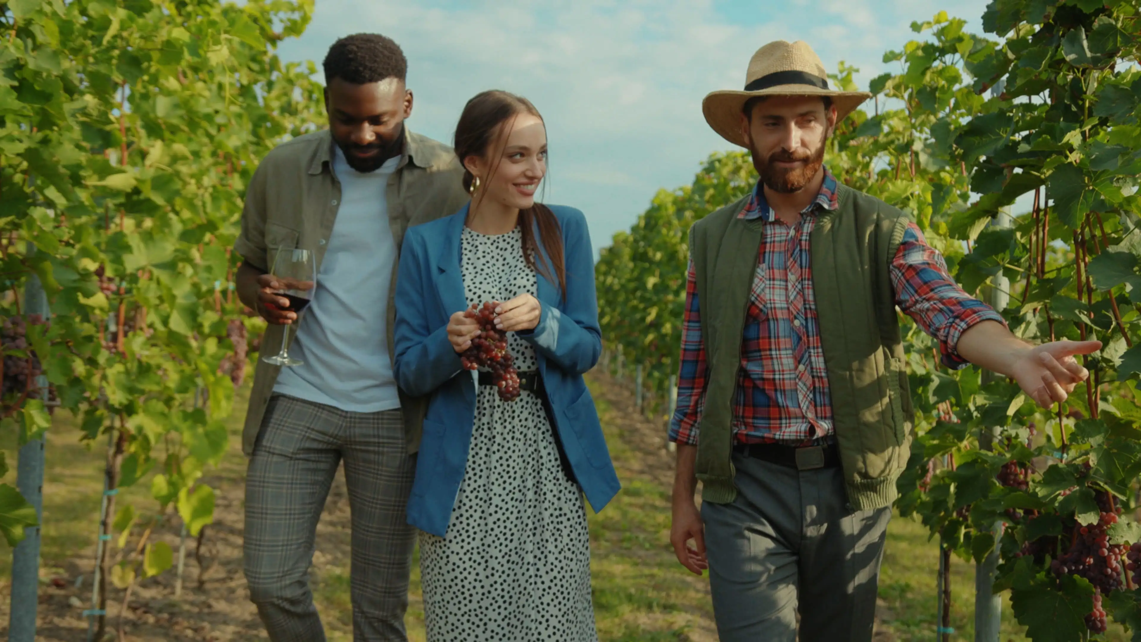 Couple walking through a Bordeaux vineyard with a winemaker.