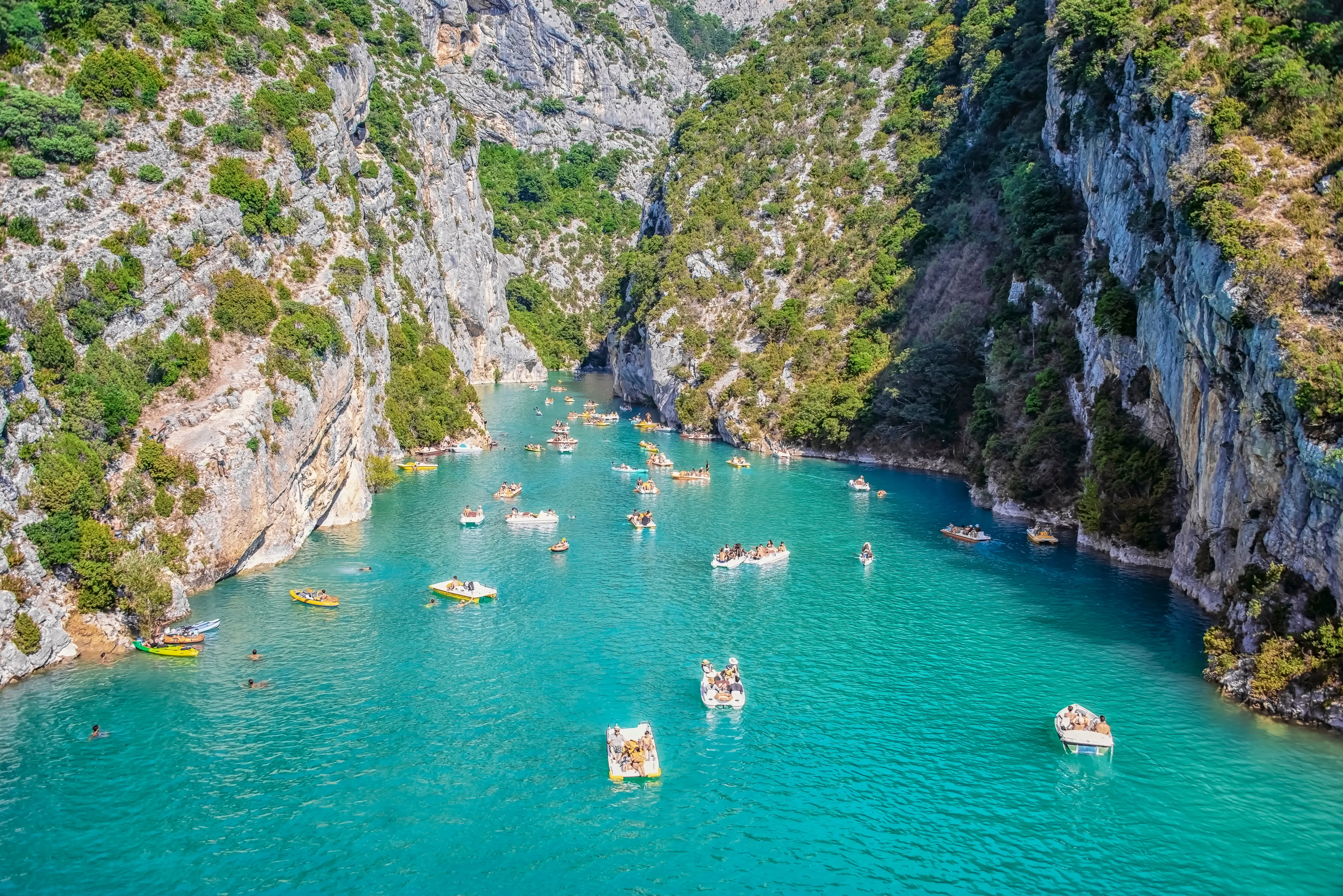 Swimmers and people in boats enjoying the turquoise waters at Sainte Croix lake