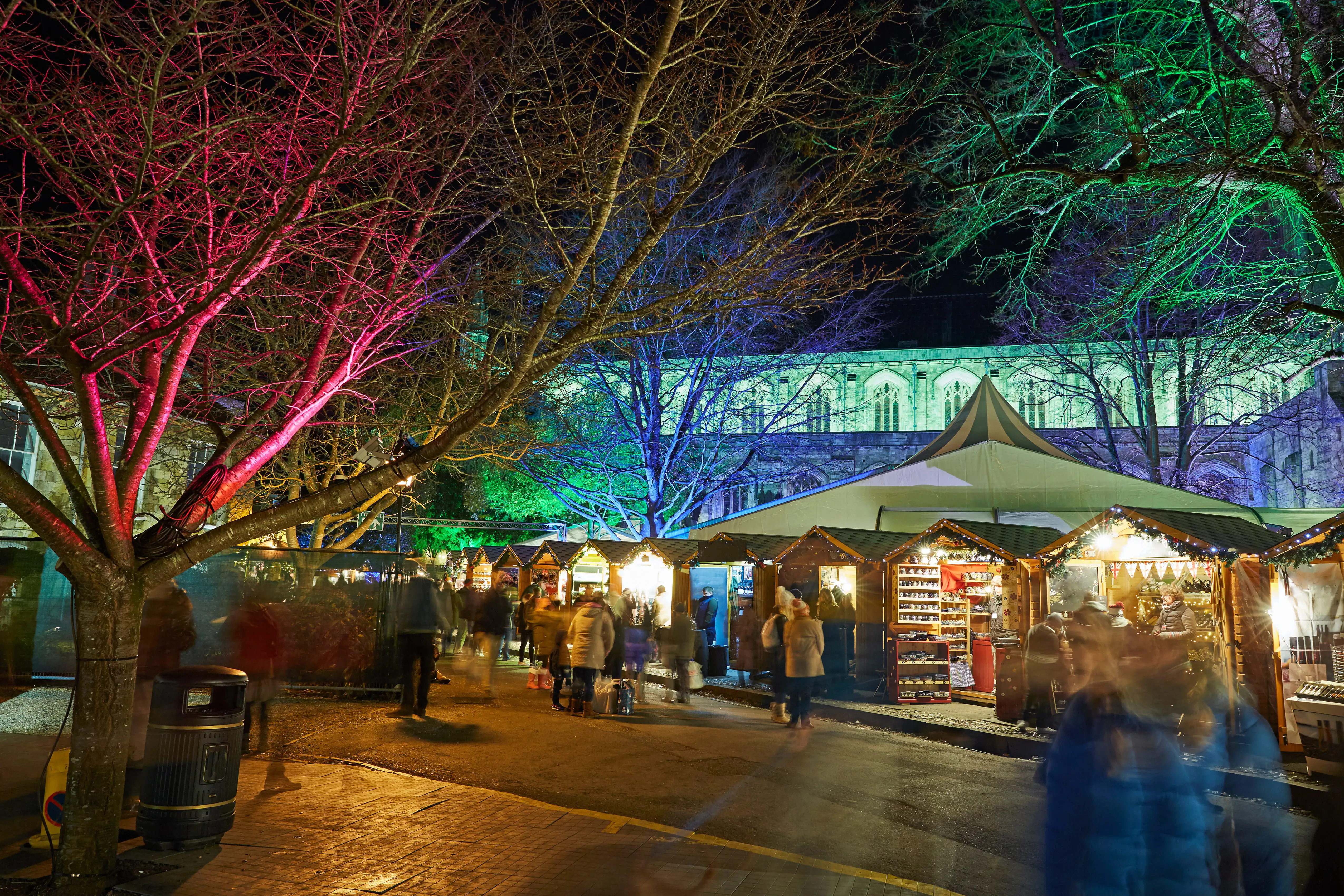 Des passants profitant du marché de Noël illuminé de Winchester.