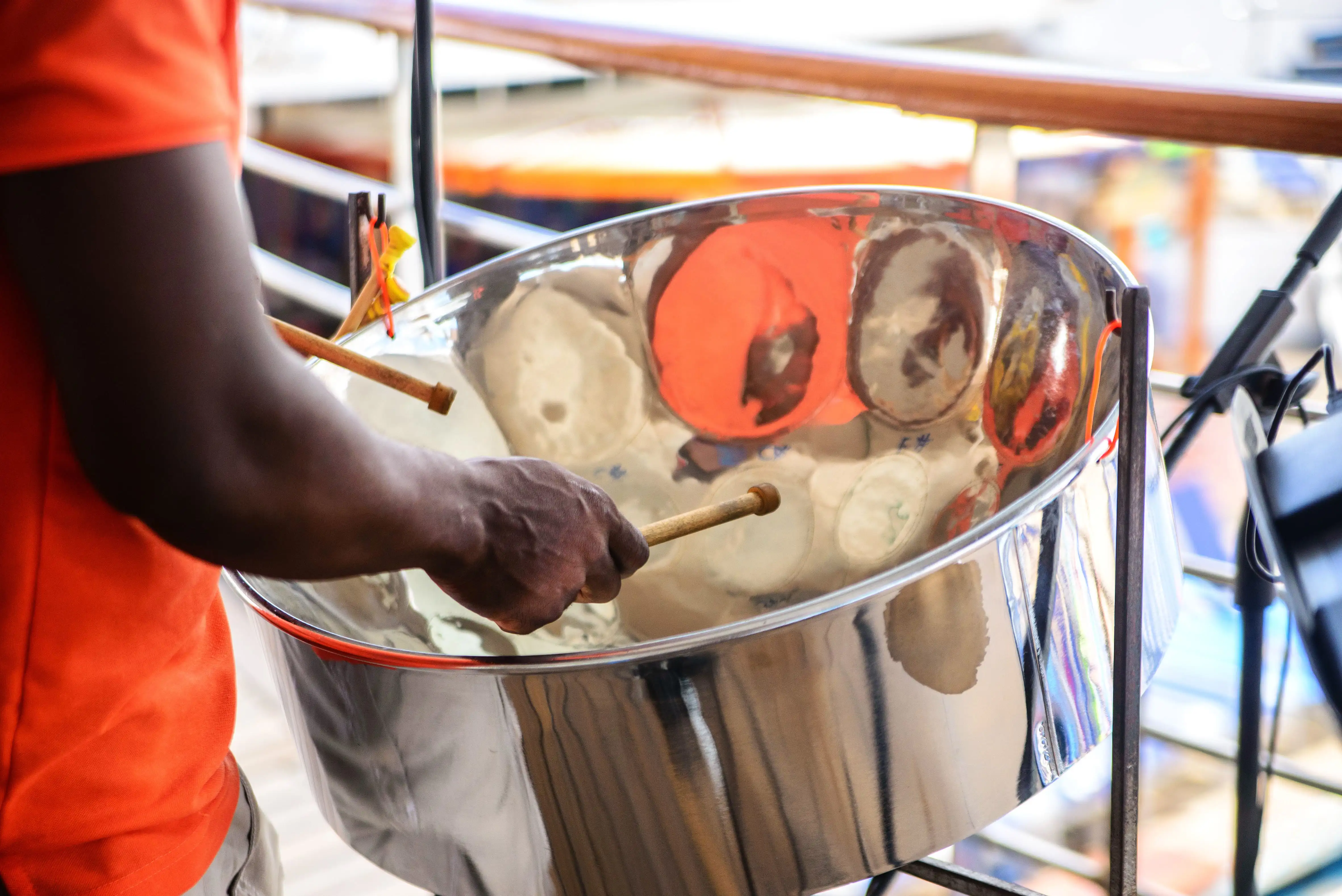 Een muzikant speelt op een steelpan-drum, gezien van achteren.