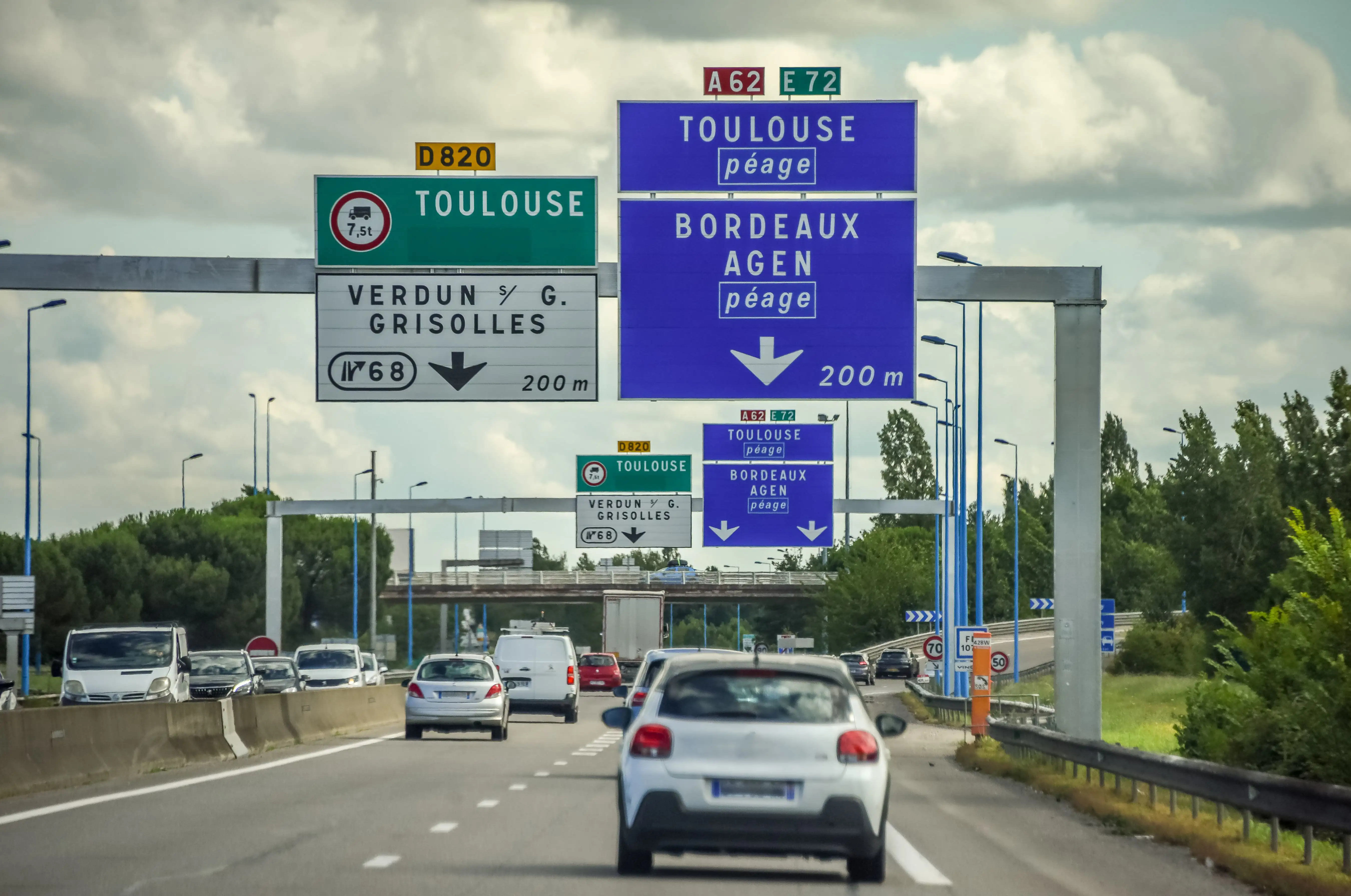Cars driving on a dual carriageway with road signs to Toulouse and Bordeaux