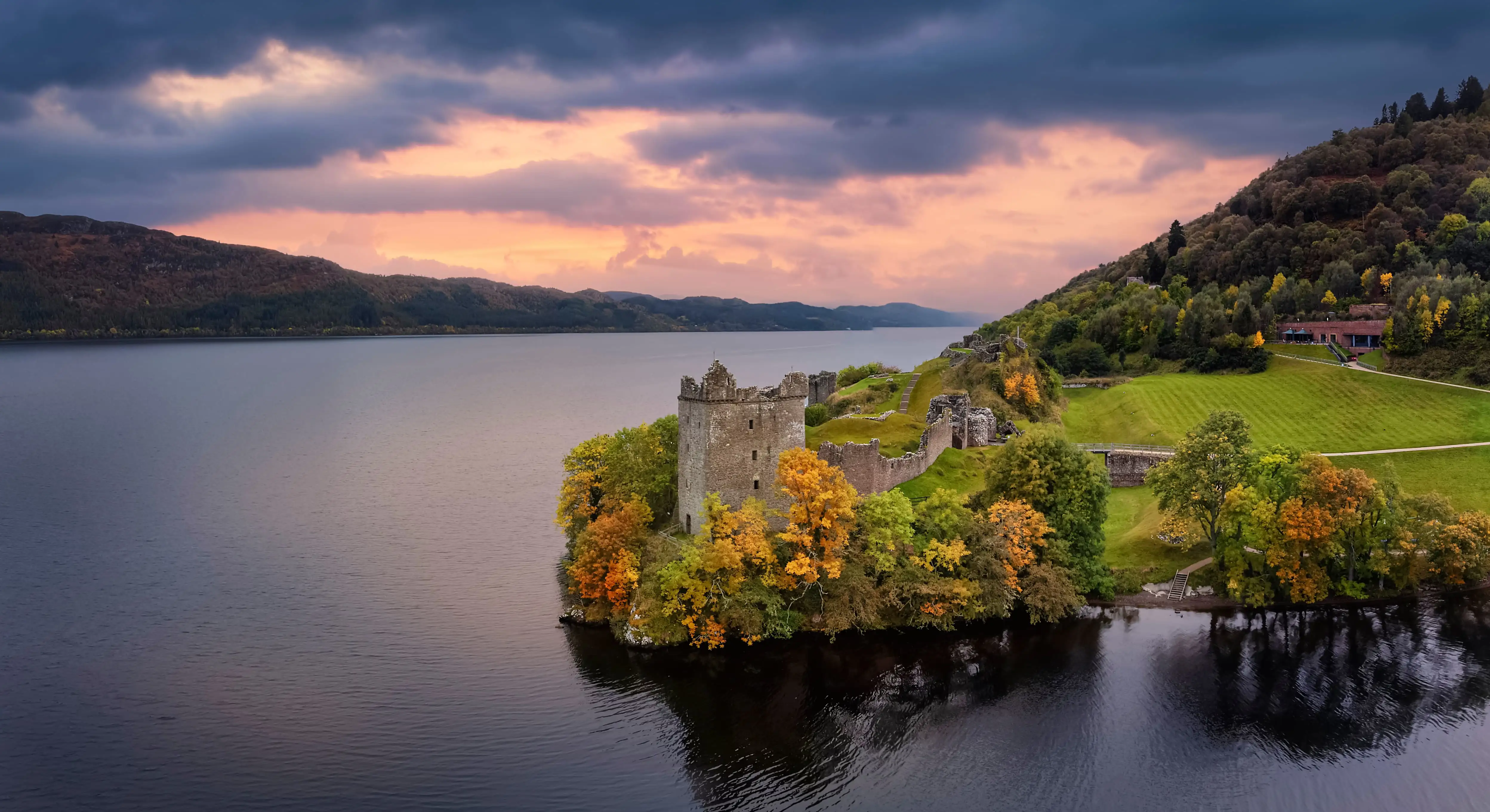 Vue aérienne du château d’Urquhart et du Loch Ness lors d’un coucher de soleil automnal.