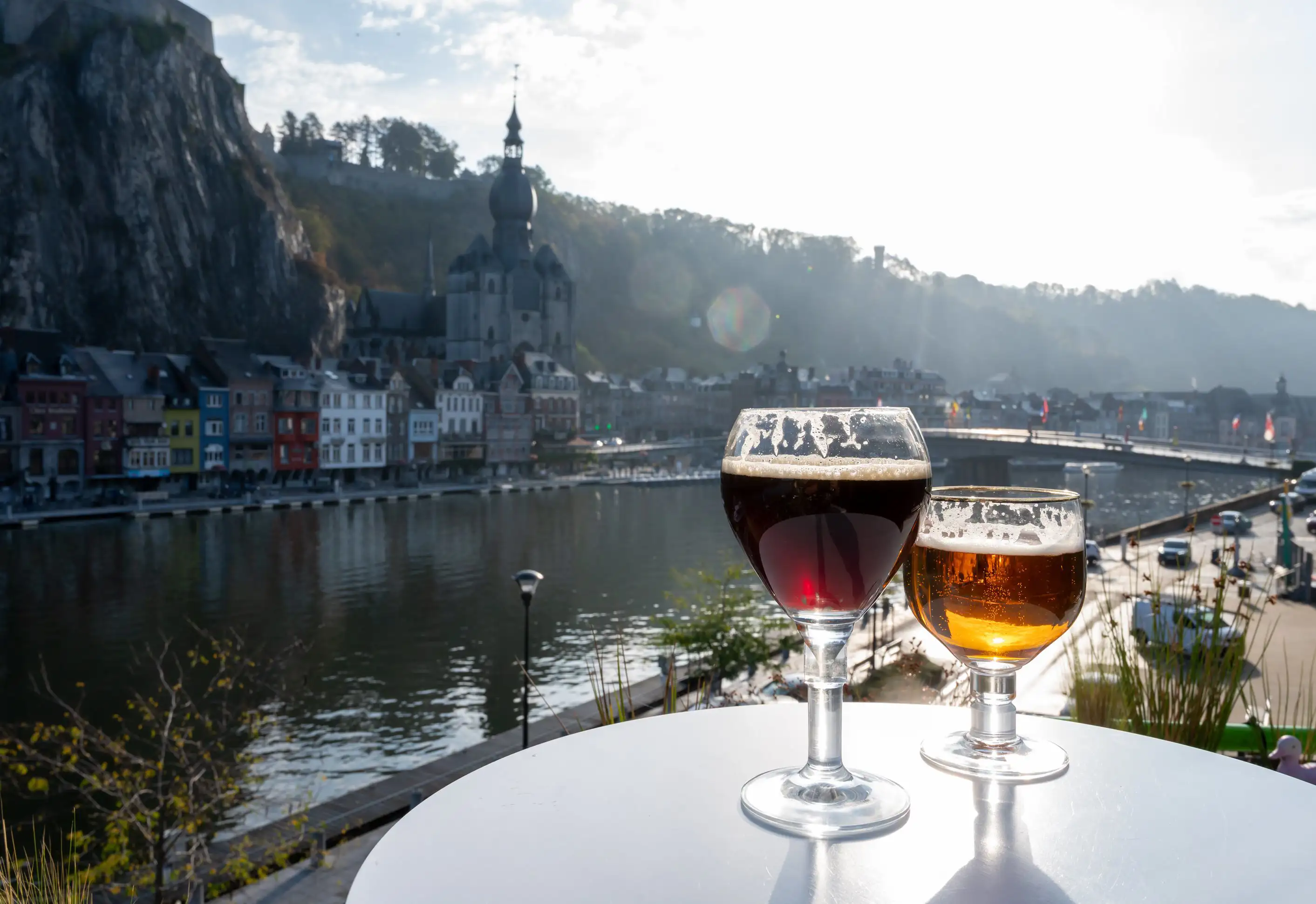 Two glasses of beer on a table overlooking Dinant