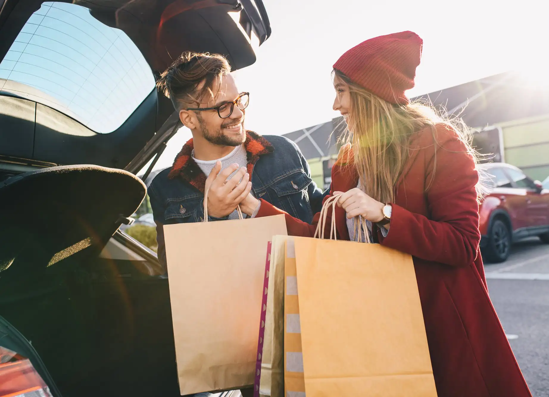Couple putting shopping bags in the boot of their car
