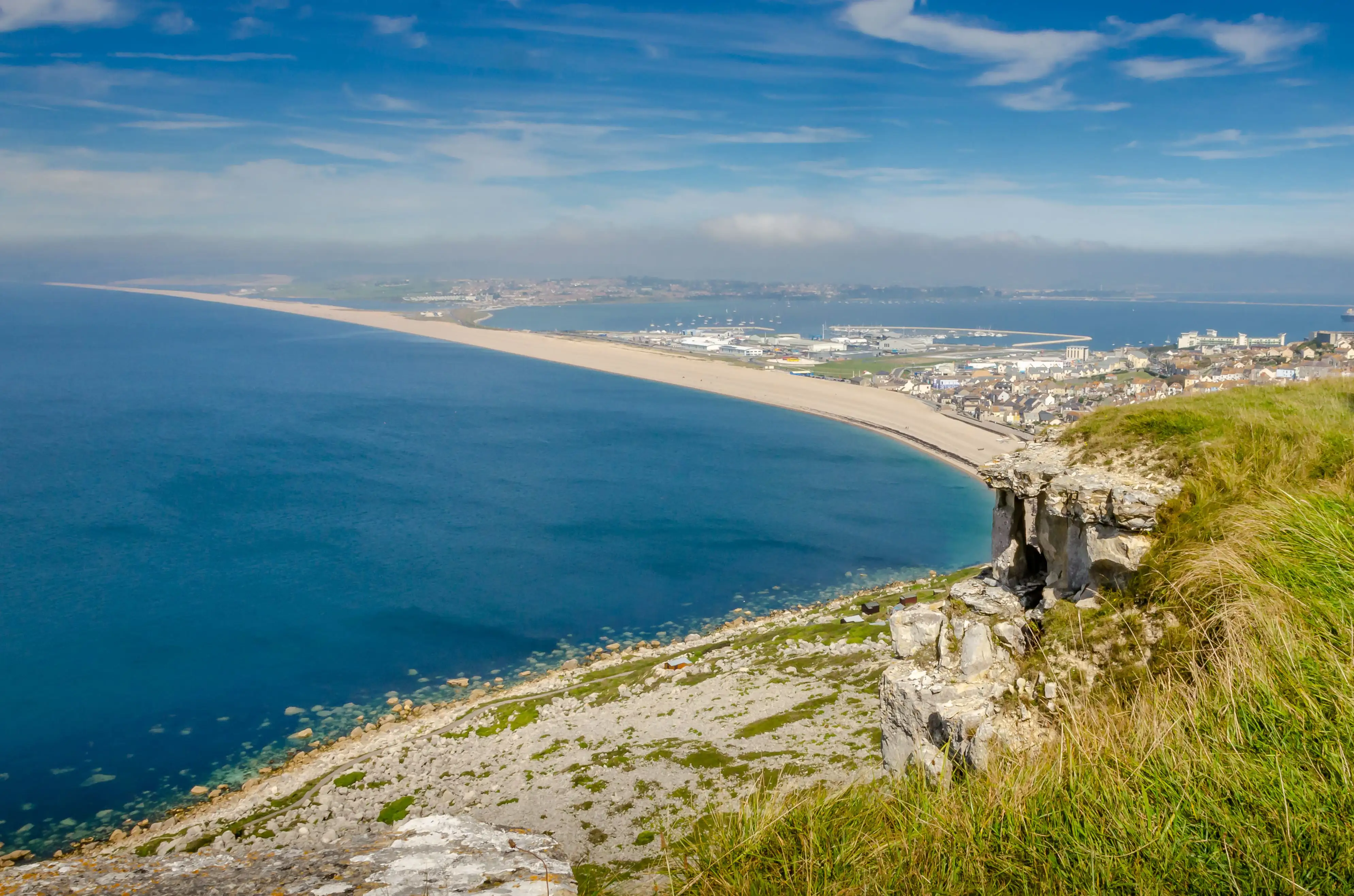 Une grande plage de sable et une baie l’été, plage de Chesil dans le Dorset