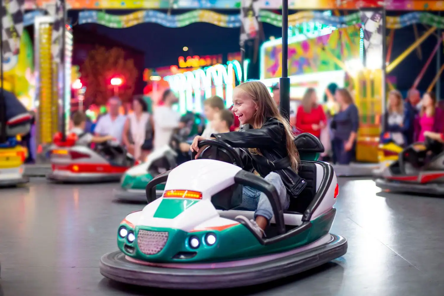 Young girl having fun in a bumper car at an amusement park