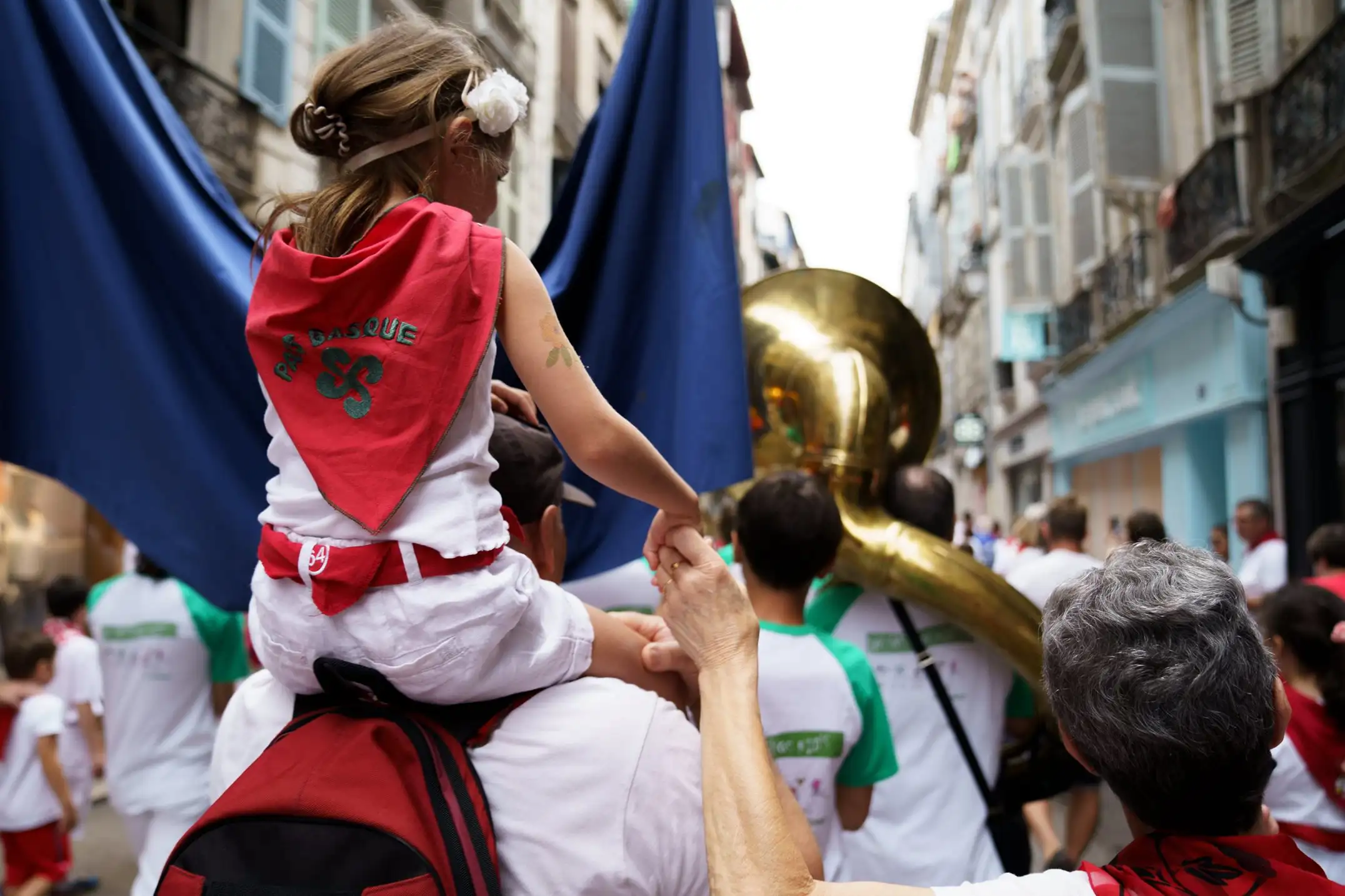 People in Bayonne walking down a street in traditional local dress