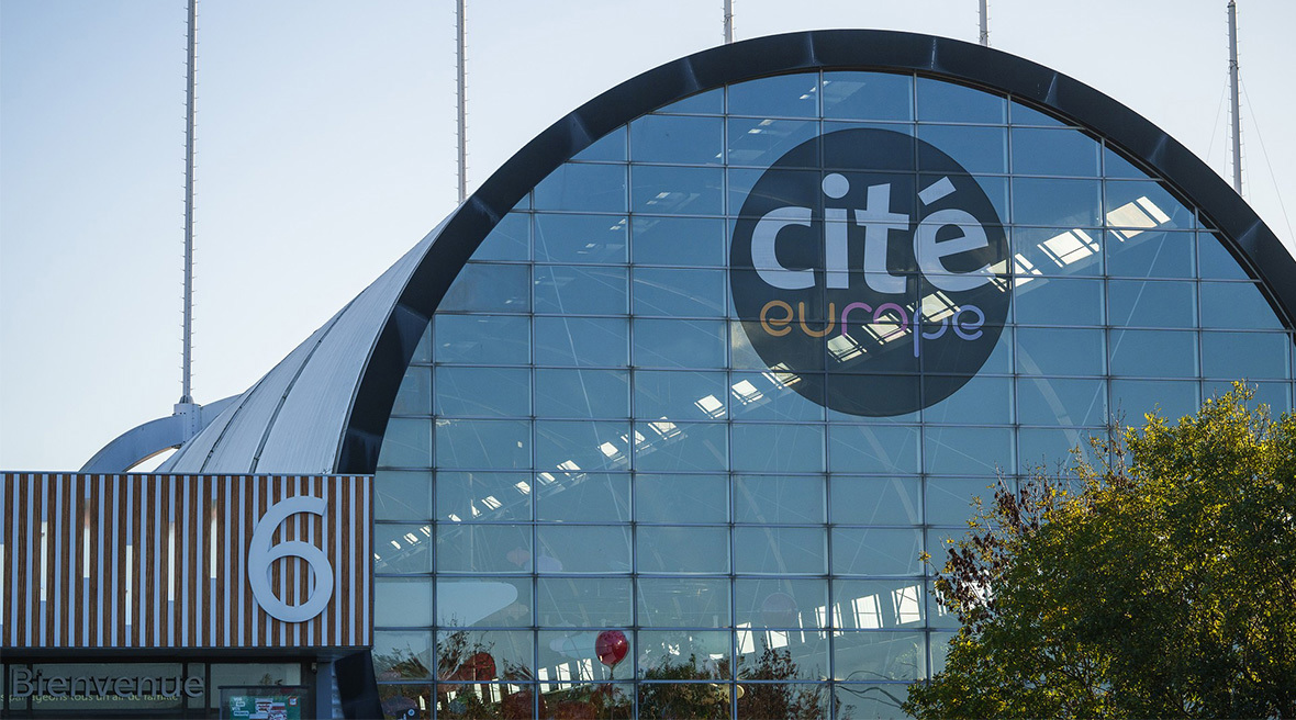 The modern, curved glass facade of the Cité Europe building