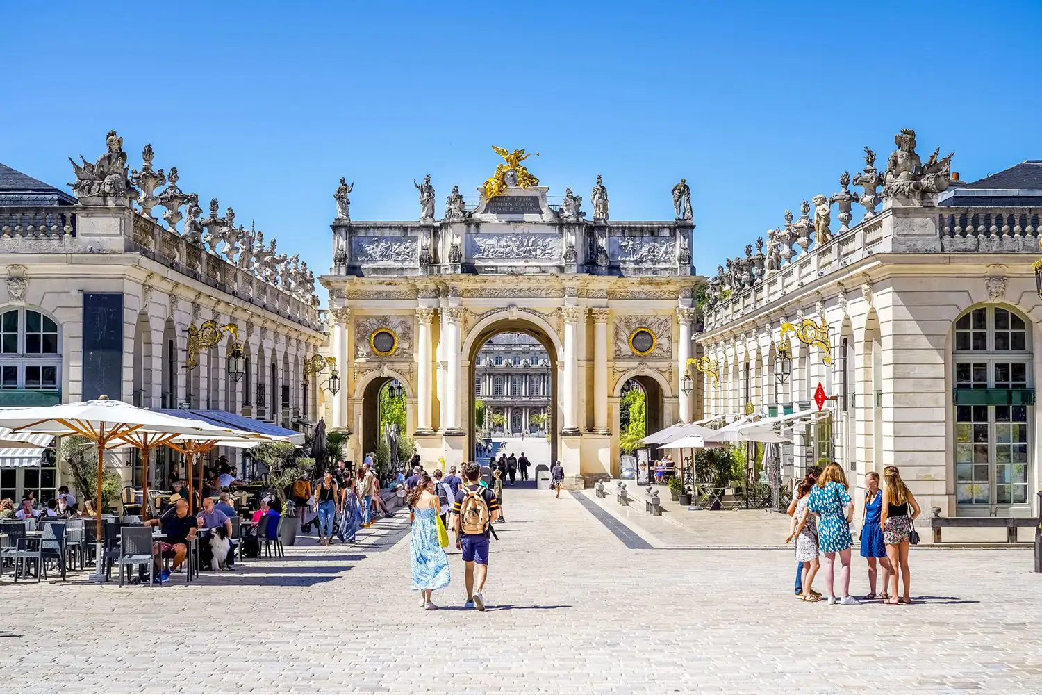 People walking and sitting at a cafe in an elegant city square on a summer’s day, Nancy, France