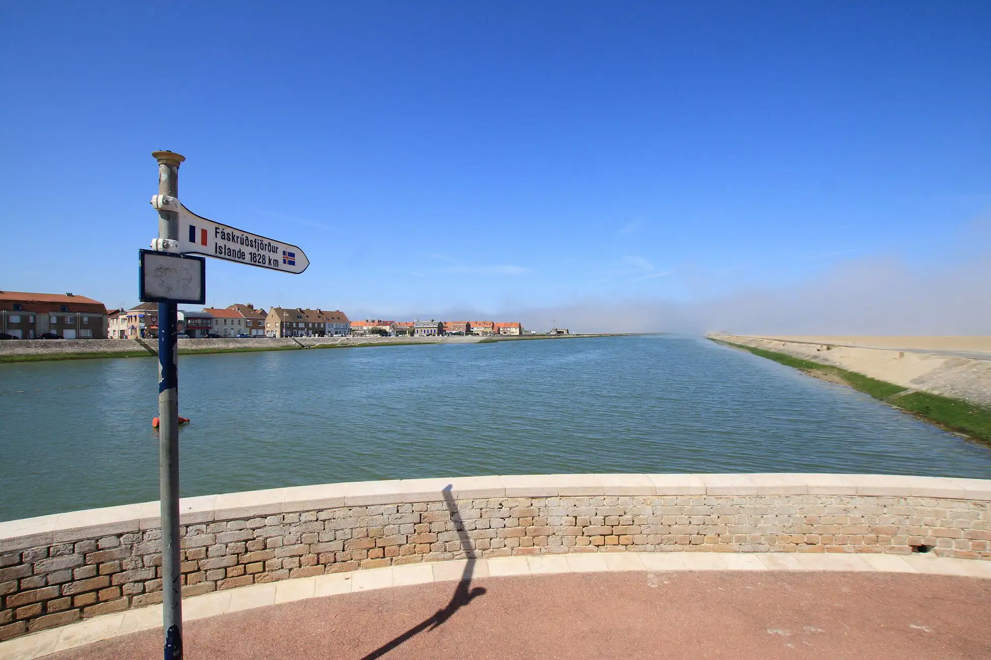 Signpost on a channel pointing towards the sea