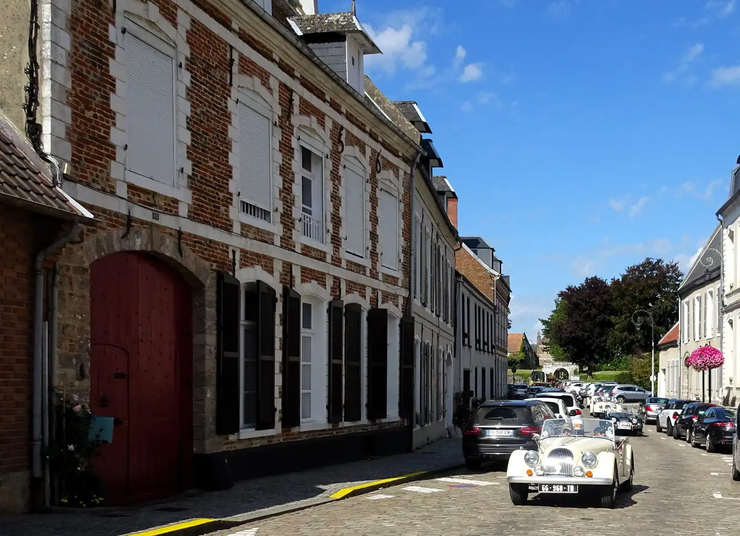 A vintage car driving on a cobbled street, Montreuil-sur-Mer, France
