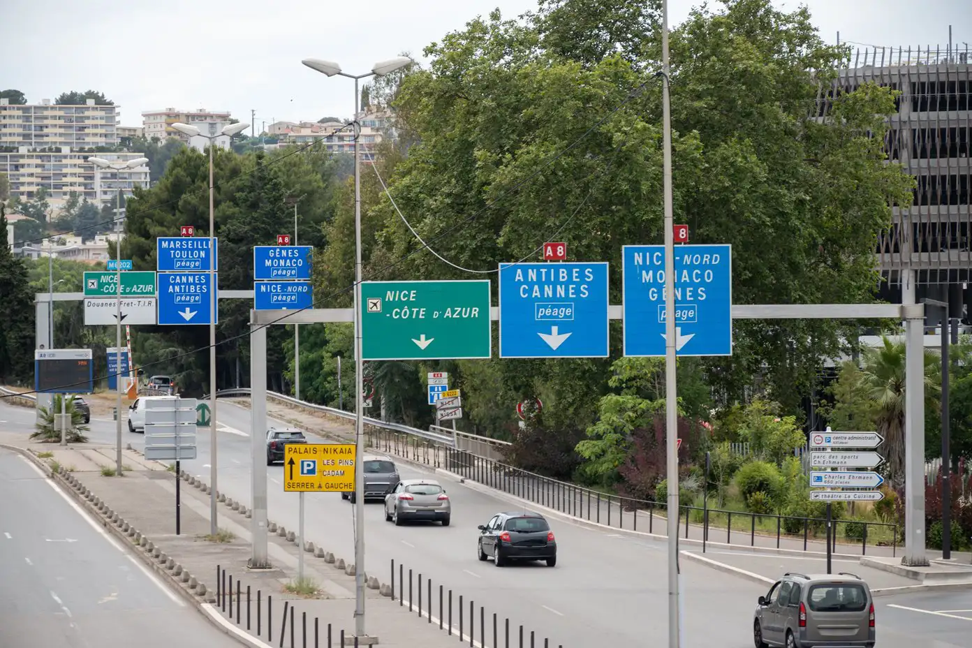 Cars driving on the A8 road with blue and green overhead signage, Nice, France
