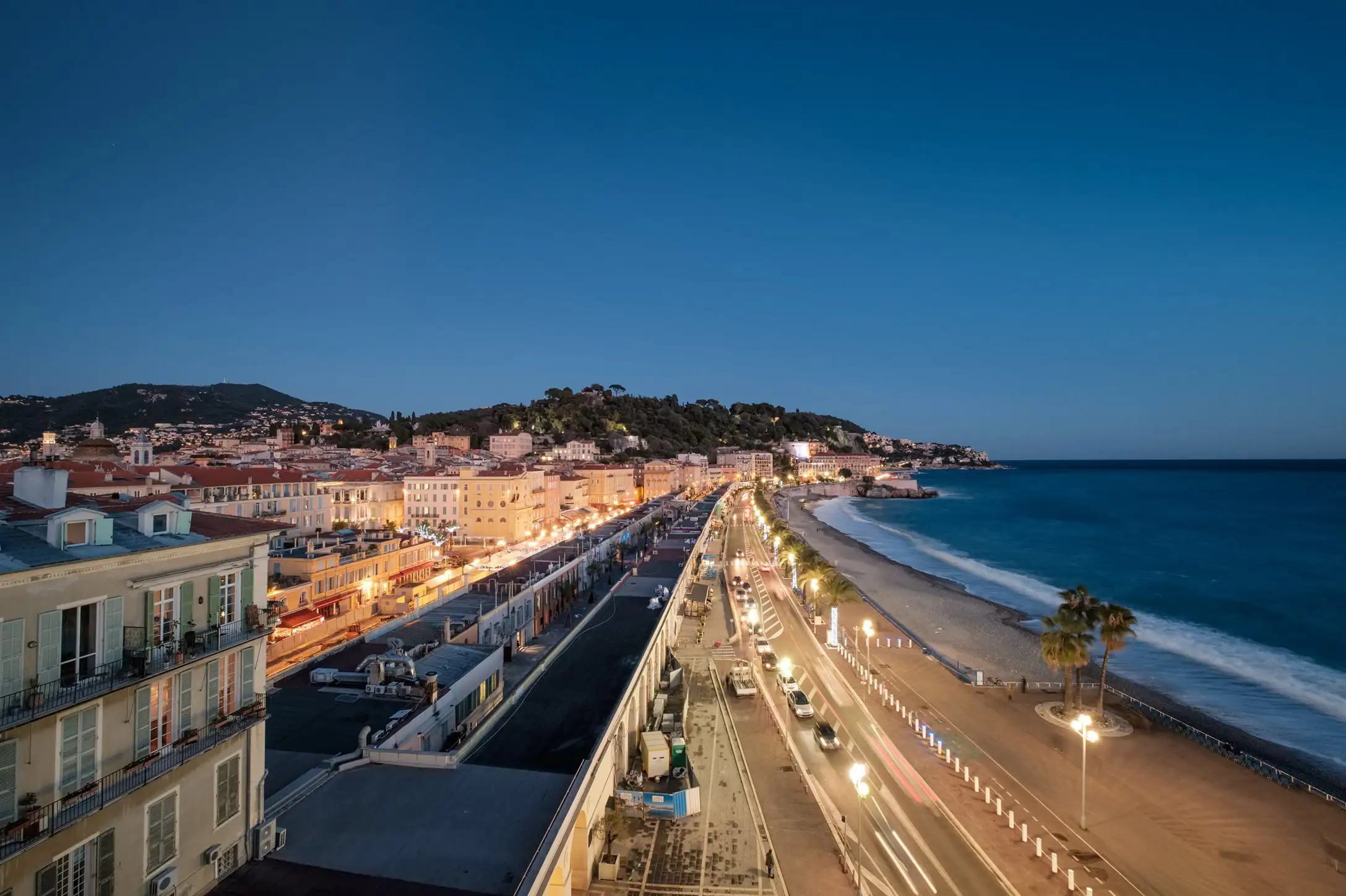 Cars driving on Nice Promenade des Anglais at dusk