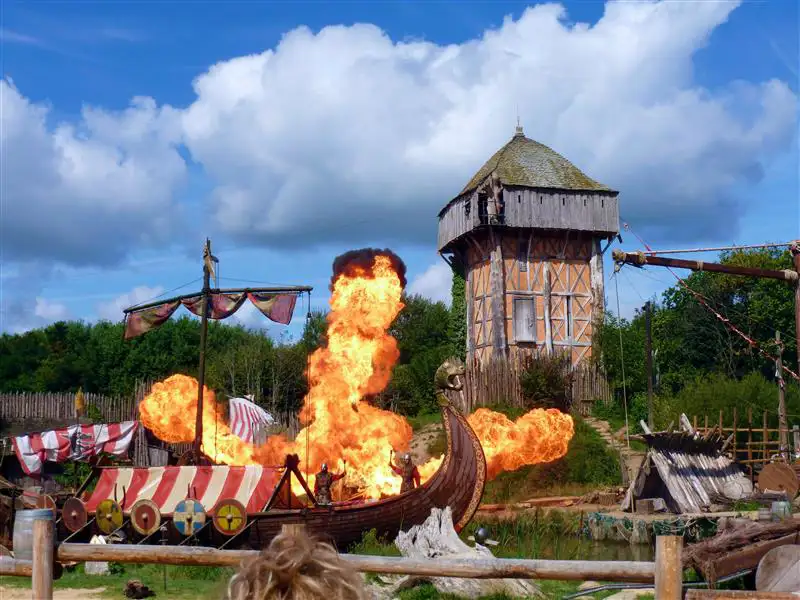 Series of thatched, half-timbered buildings on stilts above a lake, Puy du Fou theme park