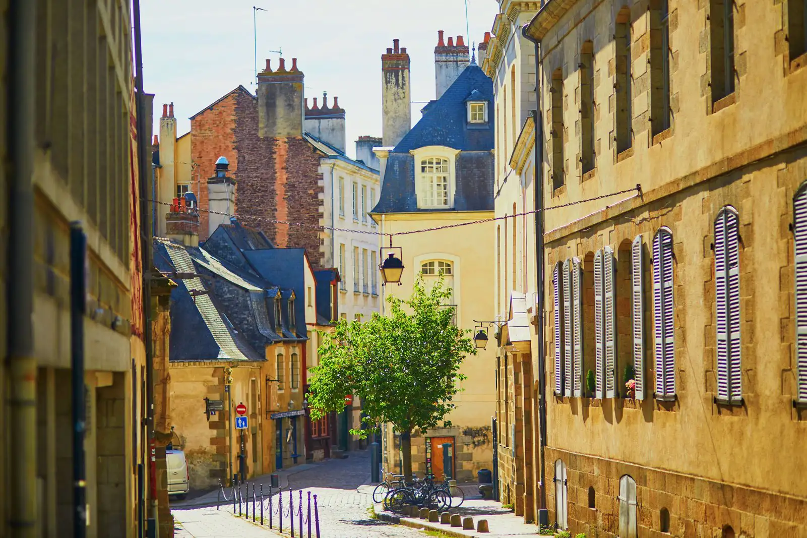 Shuttered windows on buildings in gently sloping street in Rennes, France