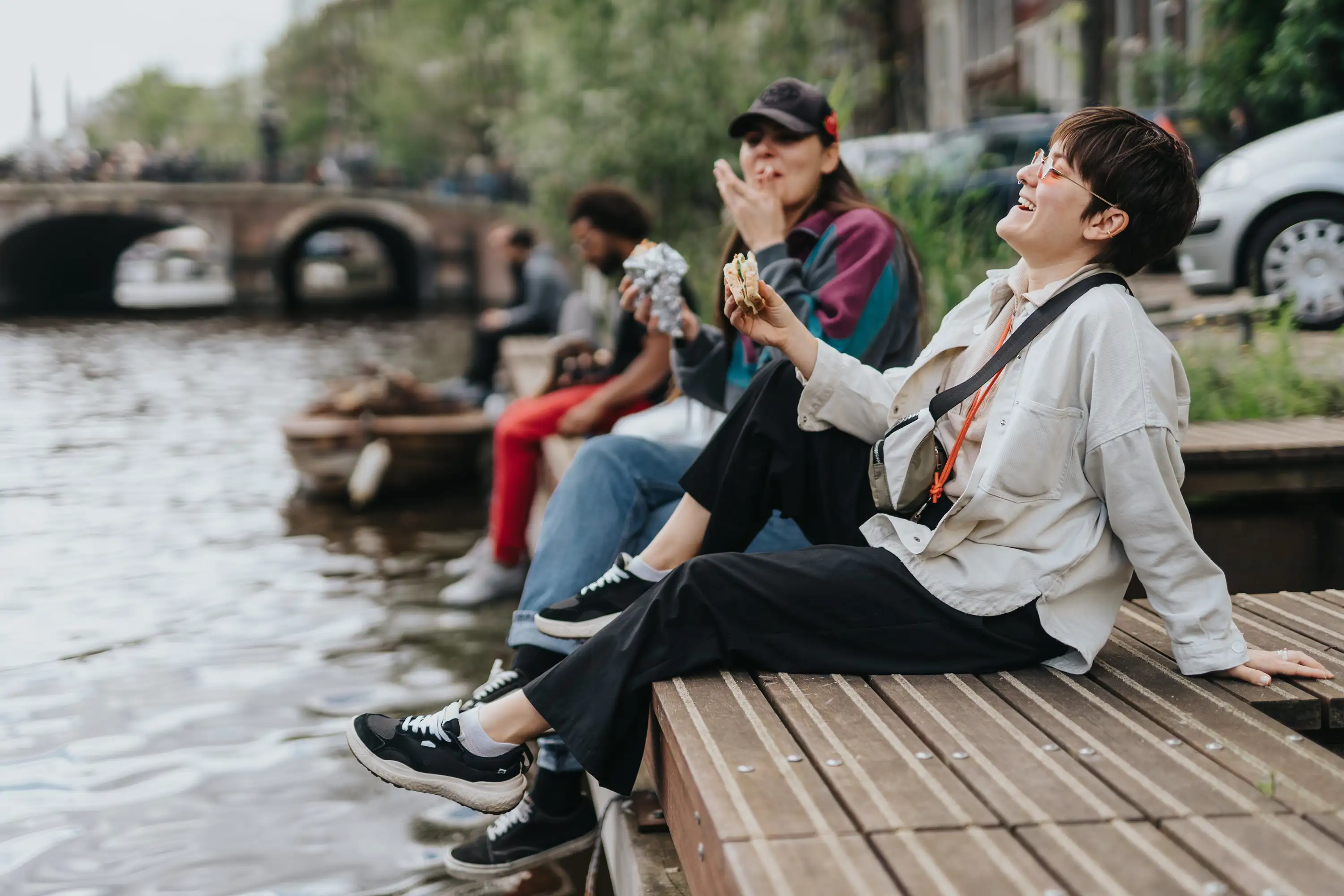 A couple sitting by a canal in Amsterdam