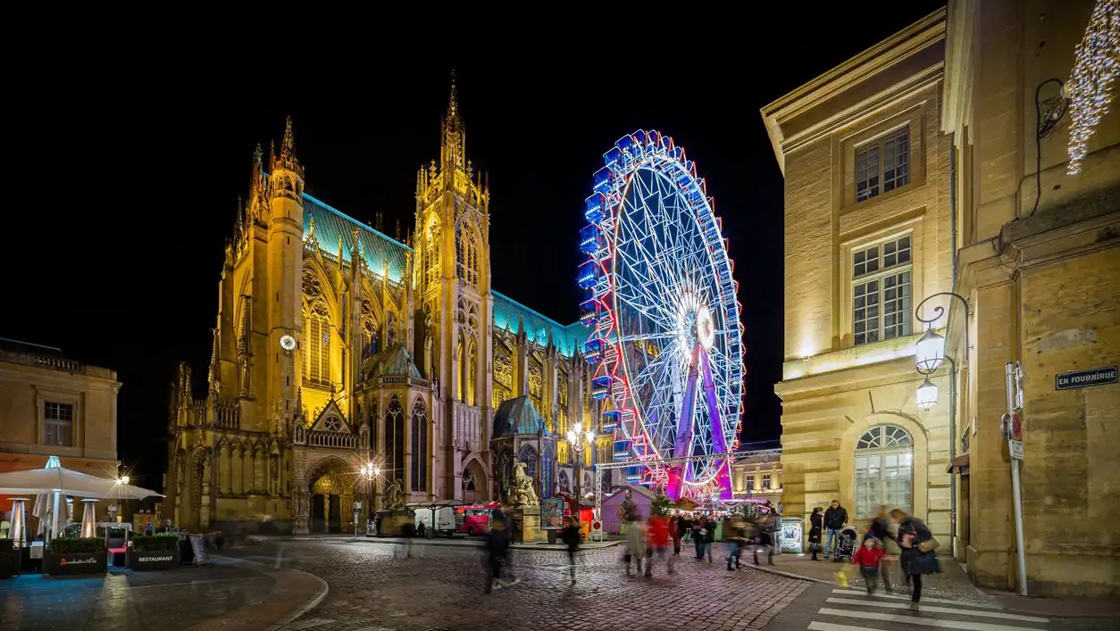 A ferris wheel near the illuminated Metz cathedral
