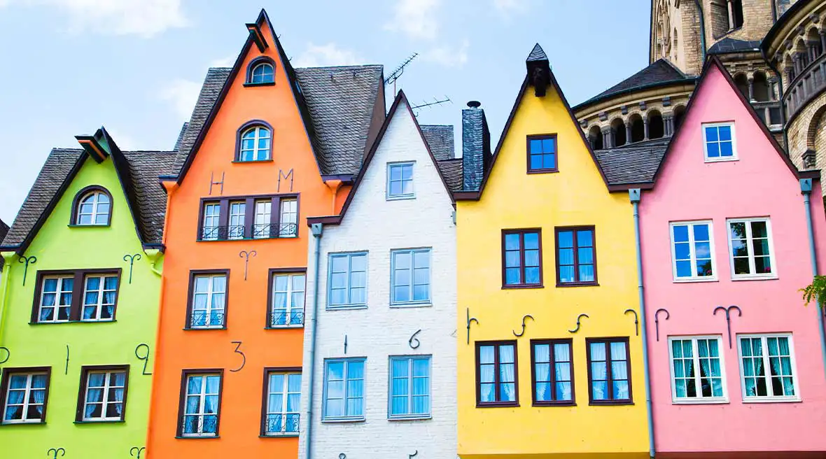 A line of multicolour three storey houses with a blue sky in the background