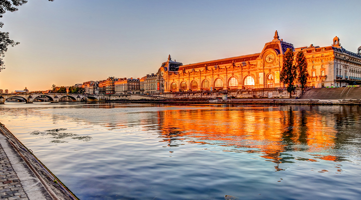 The Musée d’Orsay, a former Paris railway station, on the banks of the Seine river in Paris at sunset.