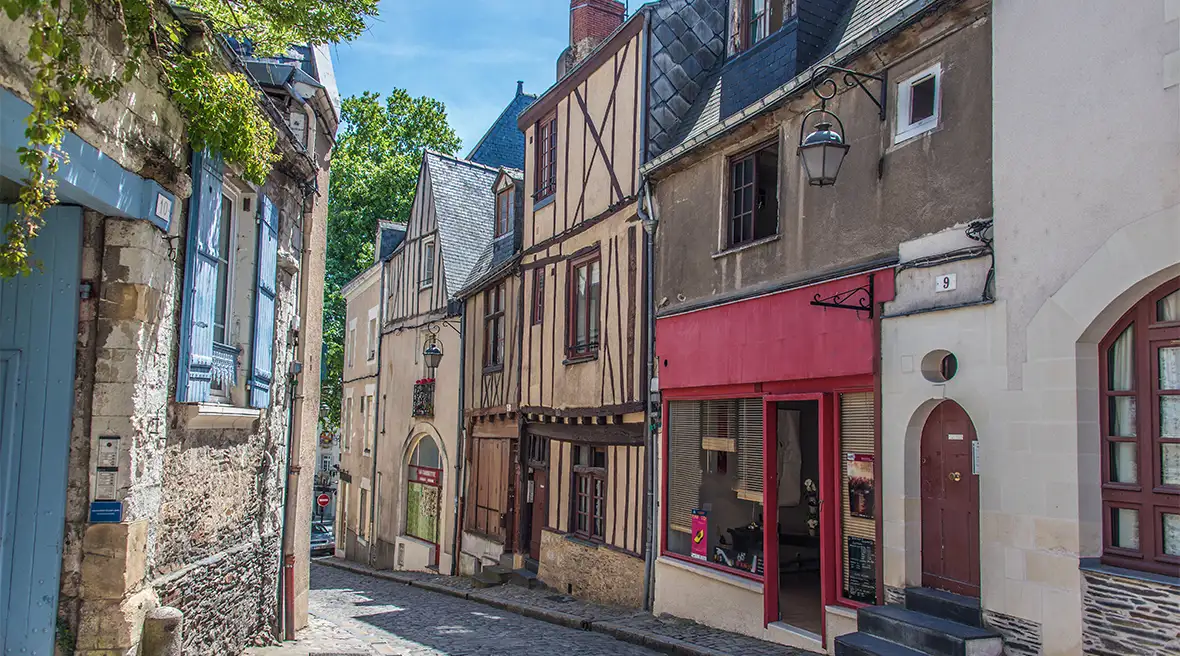 A cobbled street with quaint half-timbered historic buildings leading downhill