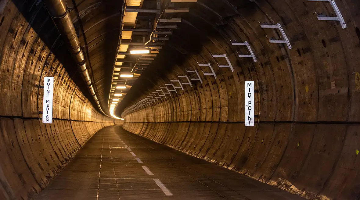 Inside of a large tunnel that’s lit and curves to the right