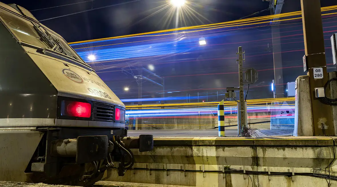 Front of a blue and white Eurotunnel Le Shuttle train with 9808 on its nose pulled in at a station terminal with blue lighting all around