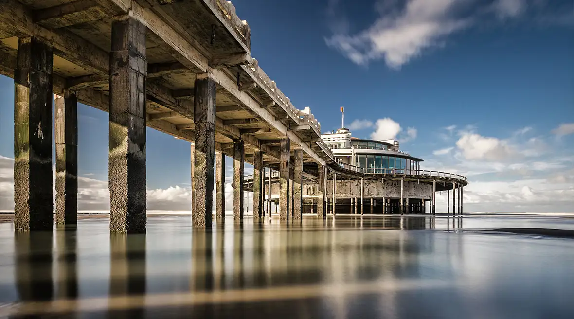 View of the pier at Blankenberge from the shore with a clear blue sky