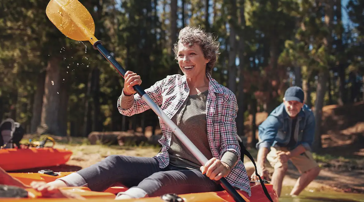 older couple paddling a kayak on a lake