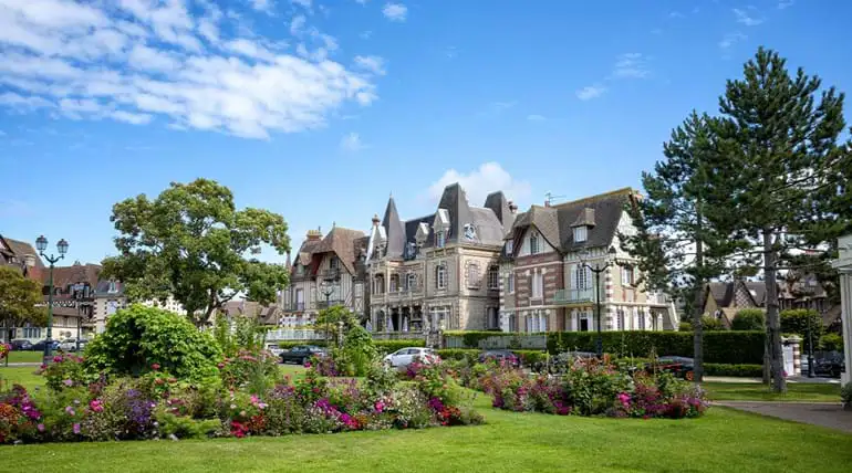 Pretty, flowered garden with an impressive large 1920s style house in the background