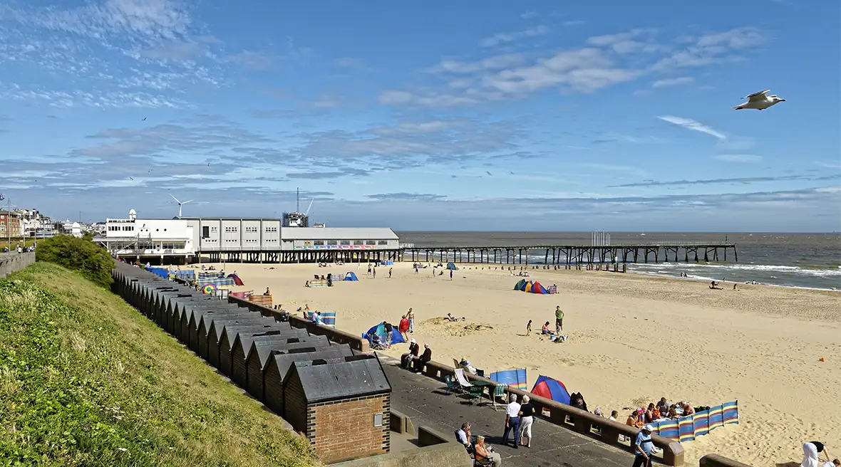 zand en strandhokjes op het strand van Lowestoft met op de achtergrond de pier