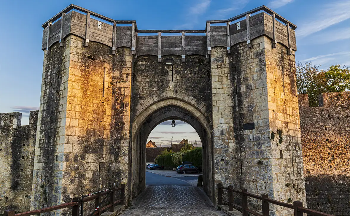 Large stone gateway with an arched entrance part of a medieval stone wall