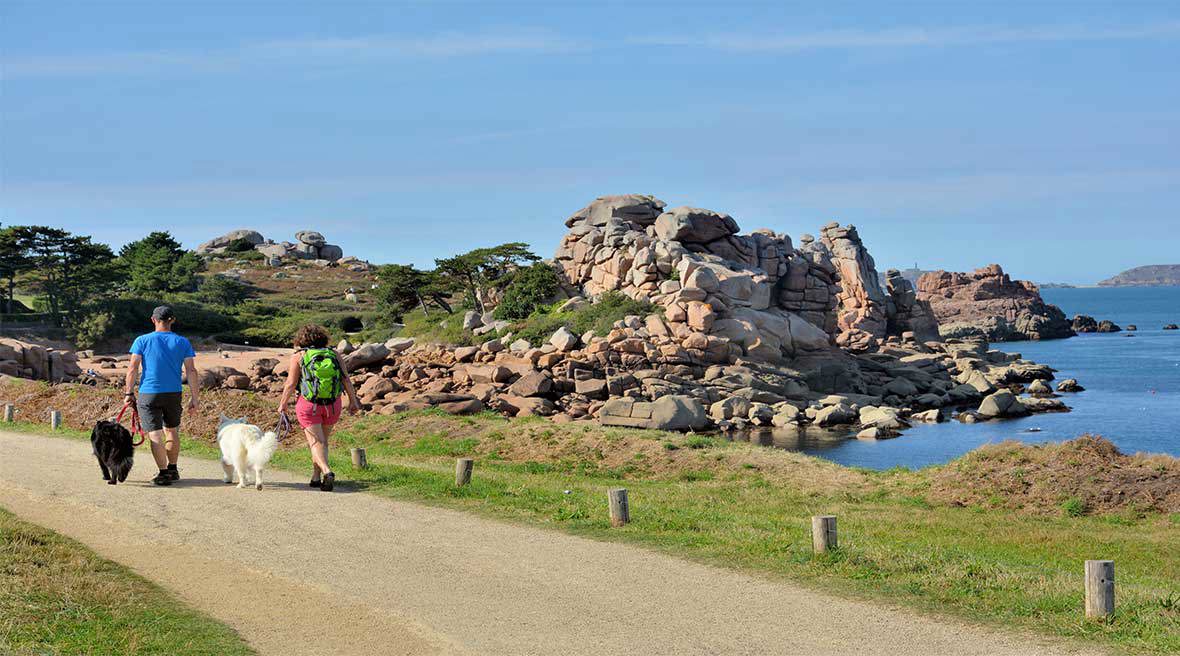 A couple who is walking on a path at seaside in Brittany, France