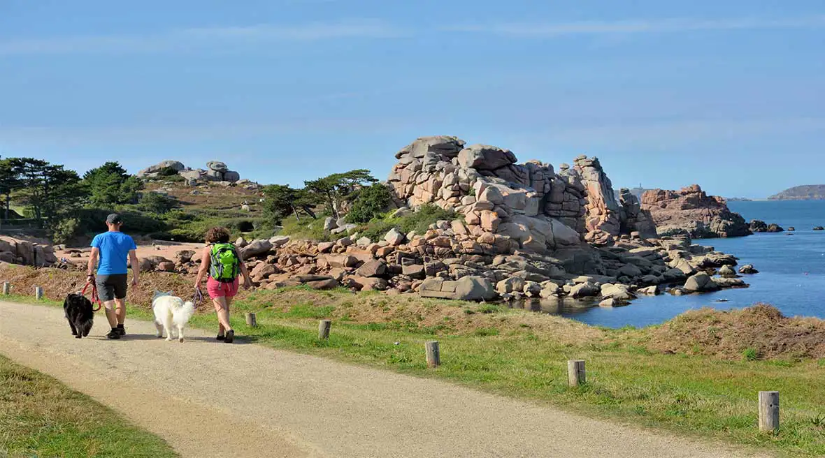 A couple who is walking on a path at seaside in Brittany, France