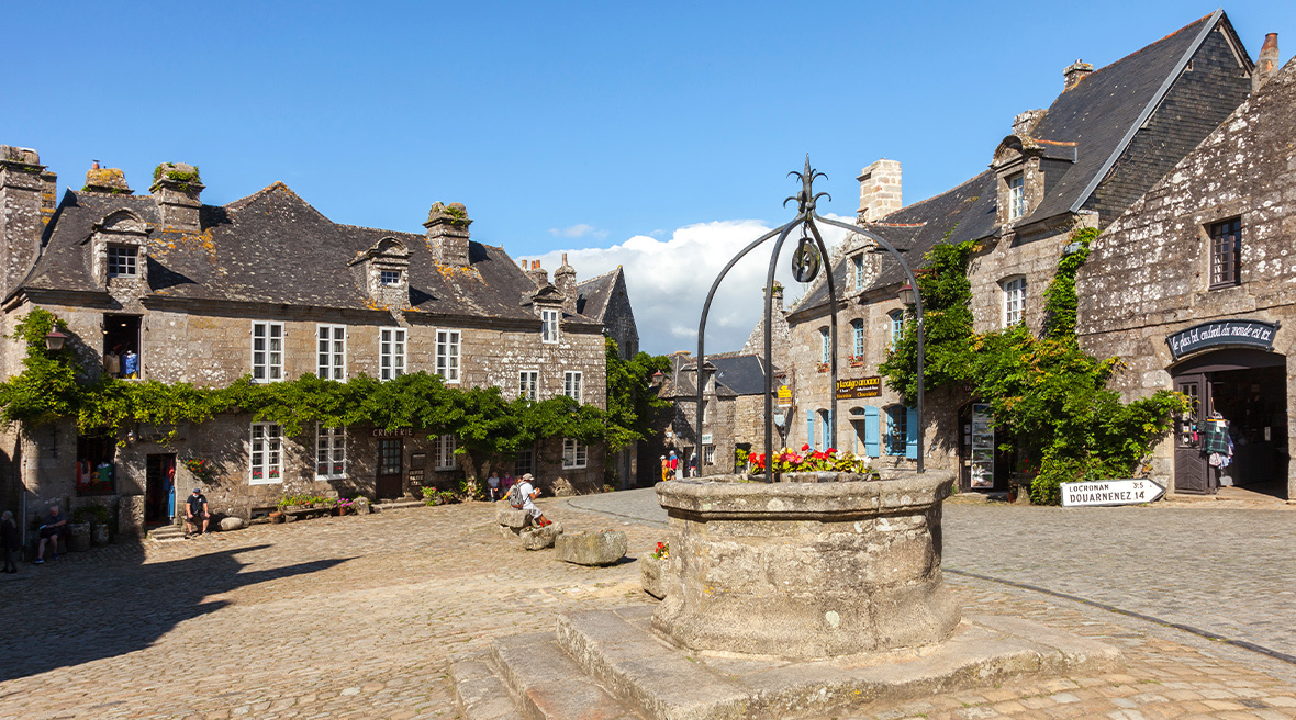 An attractive village square with period stone properties and a well.