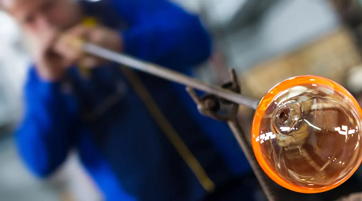 A glassblower at work in Rouen, continuing a timeless craft that has been practiced for centuries, involving skilfully shaping molten glass.