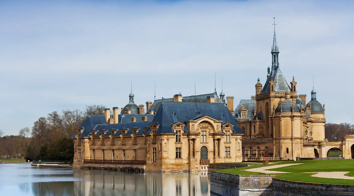 fairytale French castle in sunlight by lake