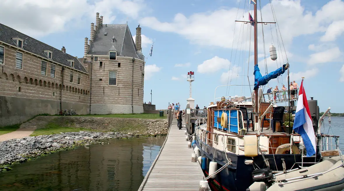 boats moored in a harbor with traditional Dutch building nearby