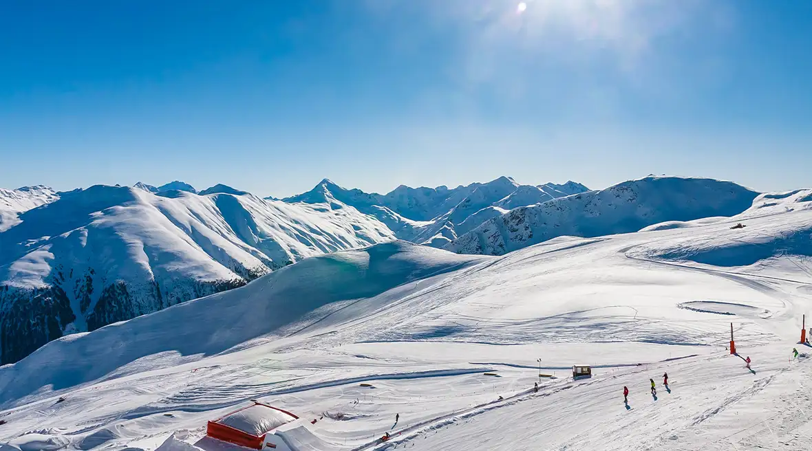 Ski slopes covered in snow with the sun beating down on them