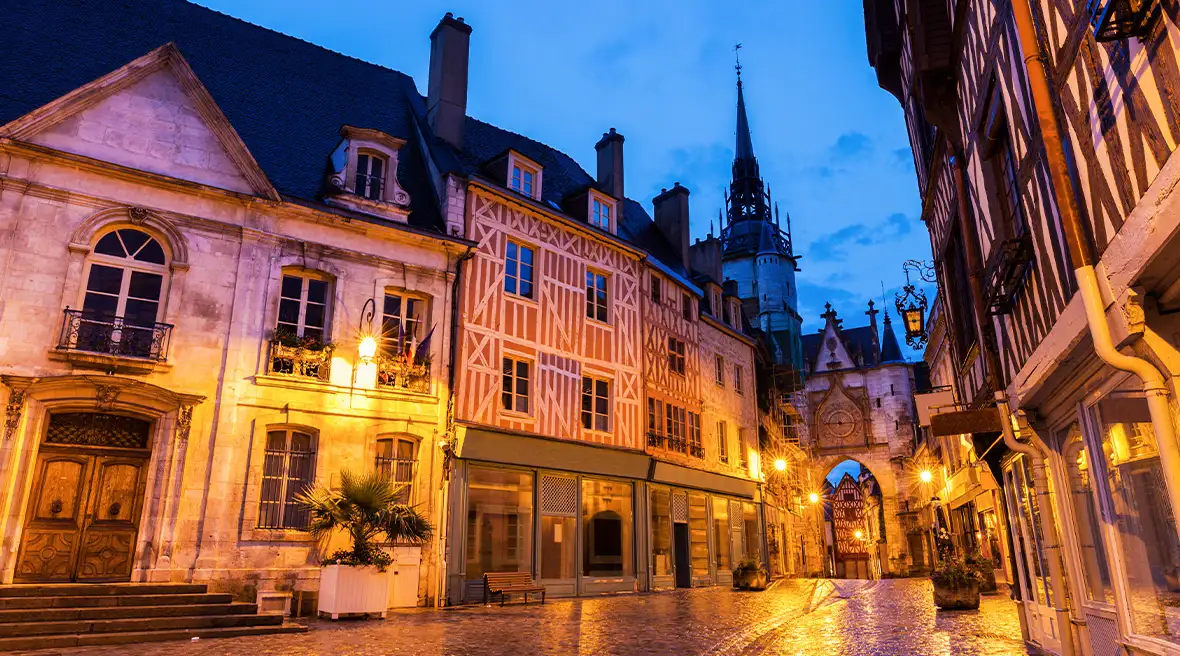 A cobbled street in a historic part of a city in an early winter evening