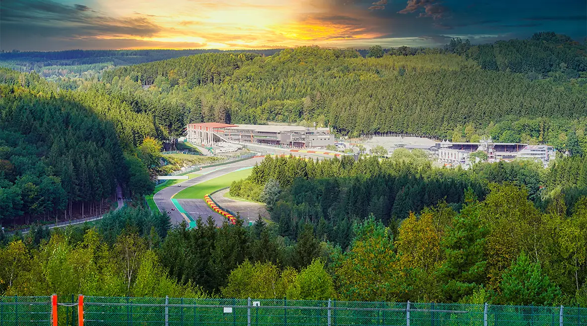 The Circuit de Spa-Francorchamps surrounded by dense forest, with the sun about to set.
